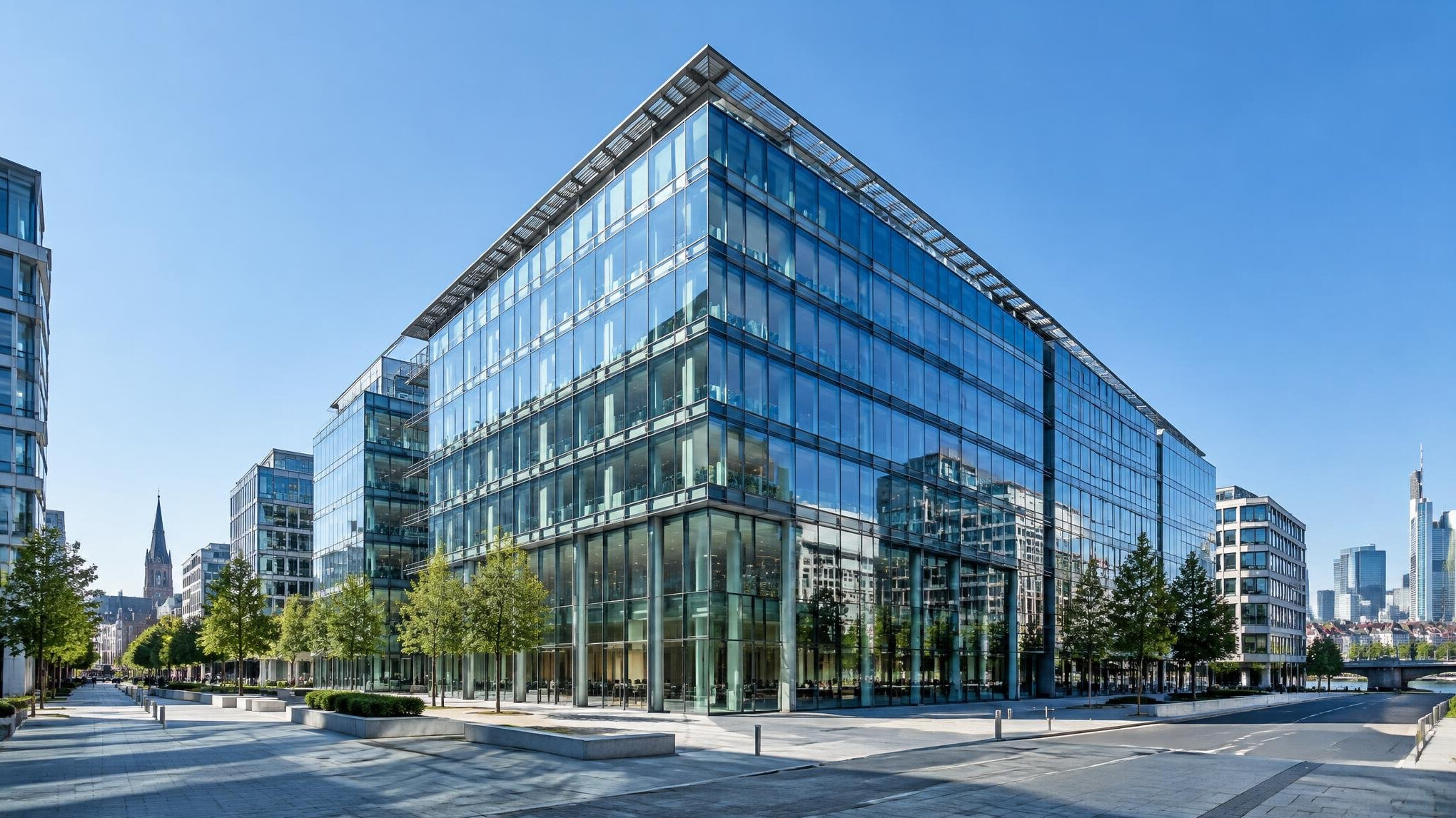 Modern glass office building exterior under a blue sky